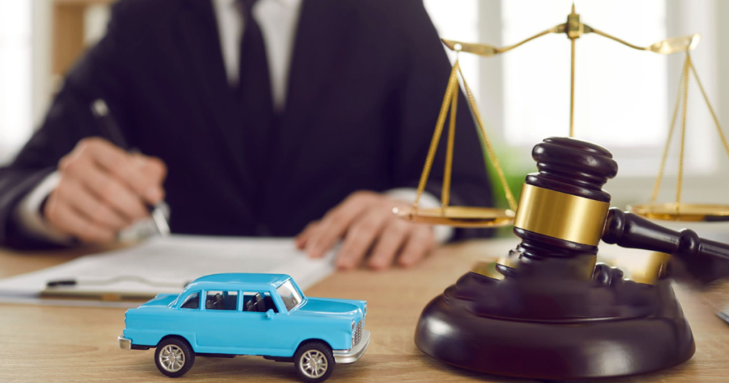 Legal gavel and scales beside a toy car.