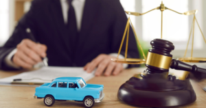 Legal gavel and scales beside a toy car.