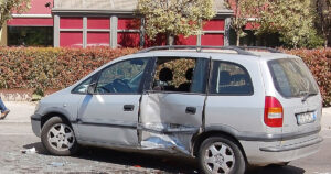 A silver minivan with severe side damage from a broadside collision