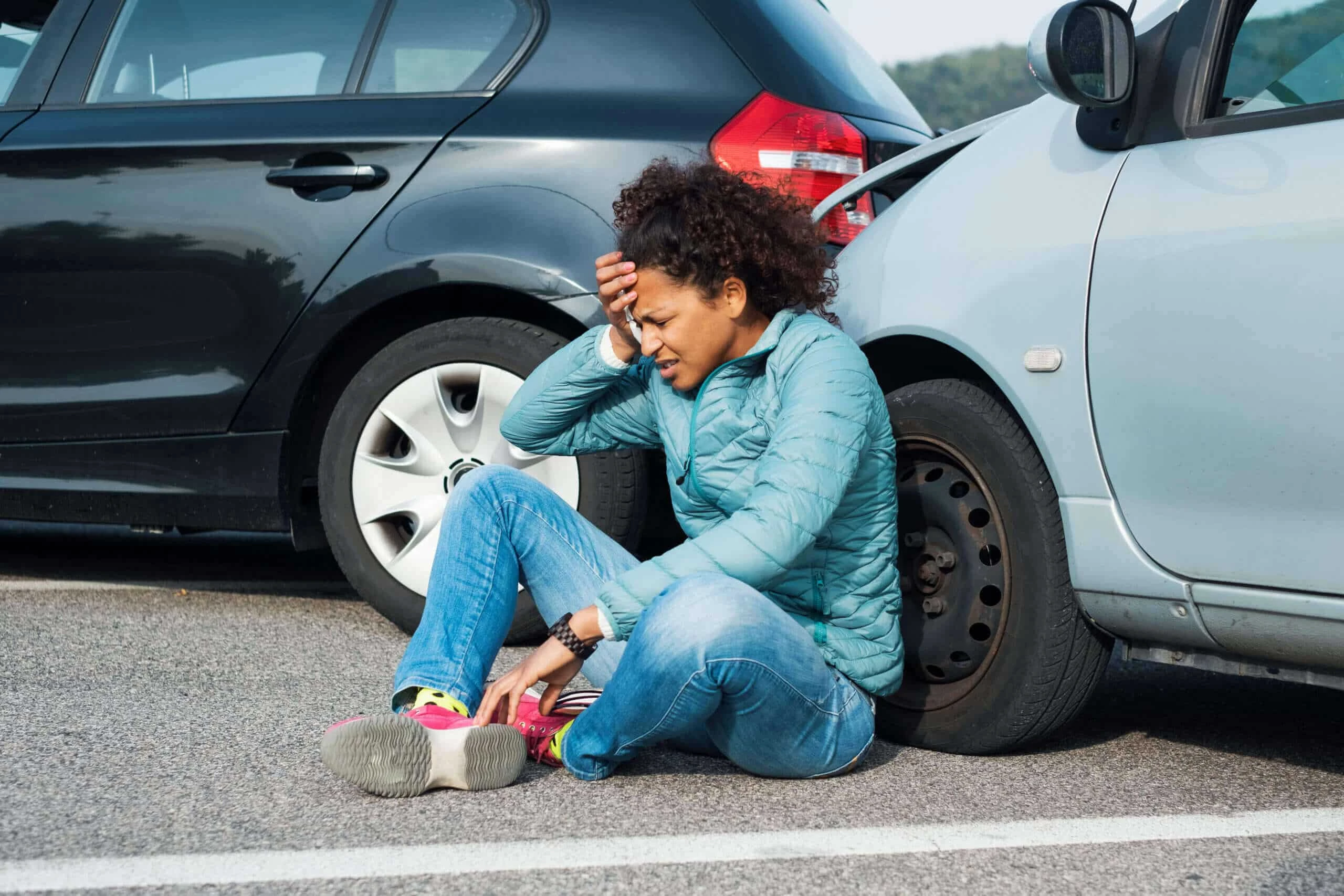 A person signing paperwork with a blue toy car sitting on a clipboard in the foreground.