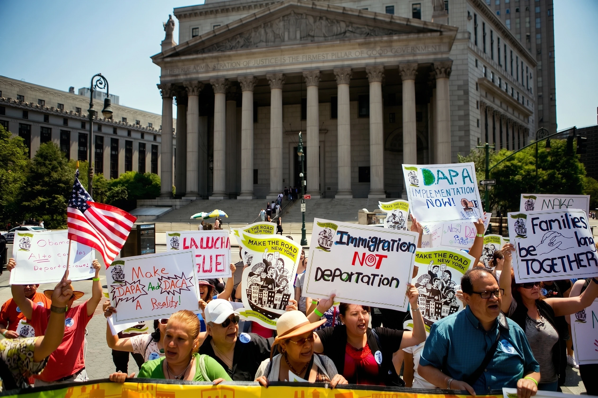 Protesters holding DAPA and immigration reform signs outside a court building.